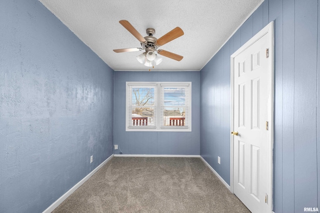 unfurnished room with ceiling fan, a textured ceiling, and carpet flooring