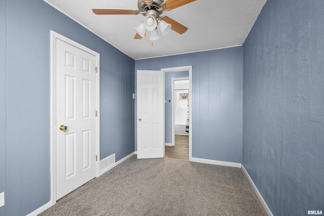 unfurnished bedroom with ceiling fan, carpet flooring, and a textured ceiling