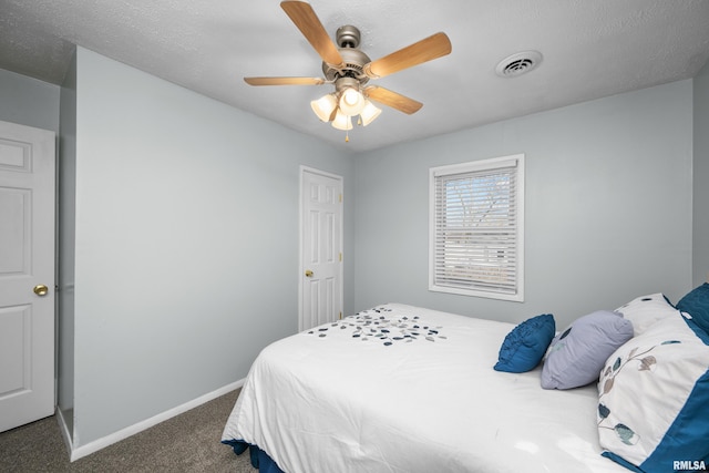 bedroom featuring ceiling fan, a textured ceiling, and dark carpet