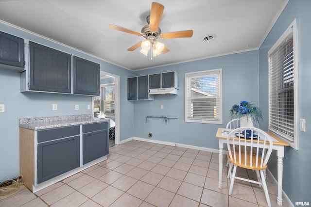 kitchen with light tile patterned flooring, ceiling fan, ornamental molding, and plenty of natural light