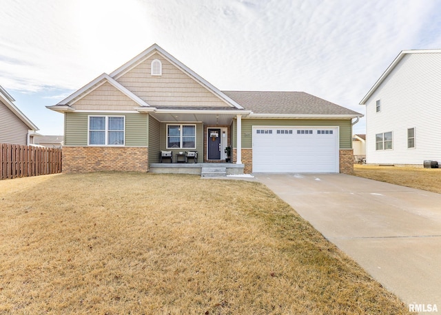 craftsman-style home with a garage, covered porch, and a front lawn