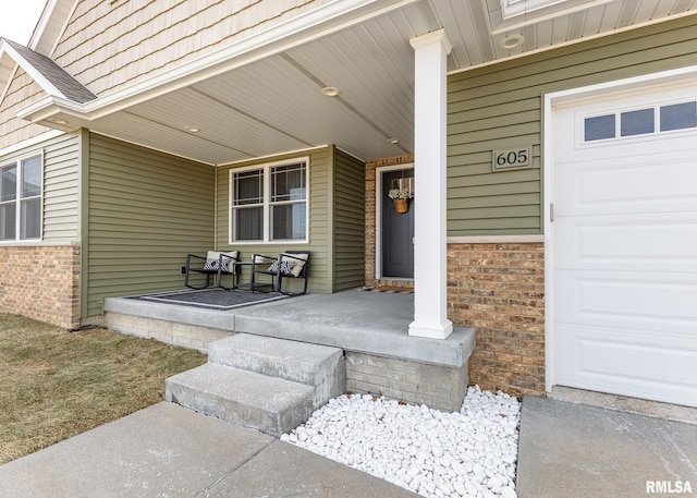 doorway to property featuring a garage and covered porch