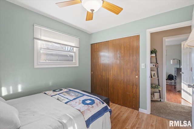 bedroom featuring ceiling fan, light hardwood / wood-style floors, and a closet