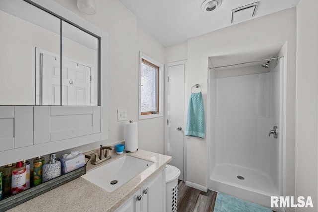 bathroom featuring walk in shower, vanity, toilet, and hardwood / wood-style floors