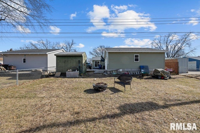 back of house featuring a yard and a fire pit