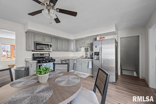 dining space featuring sink, light hardwood / wood-style floors, and ceiling fan