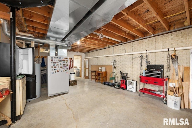 basement with brick wall and white fridge