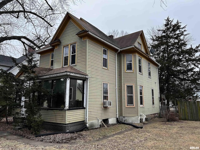 view of side of property with a sunroom and cooling unit