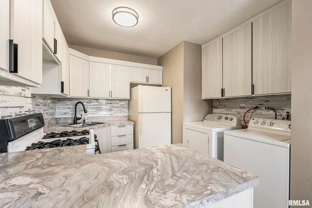 kitchen with sink, tasteful backsplash, separate washer and dryer, range with gas stovetop, and white fridge