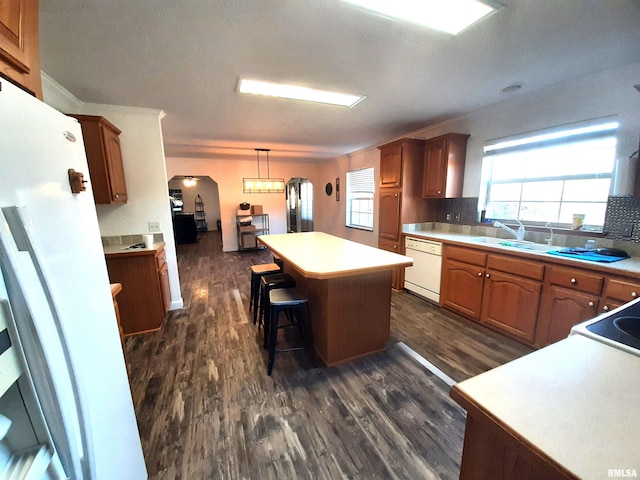 kitchen with sink, hanging light fixtures, a center island, white dishwasher, and decorative backsplash