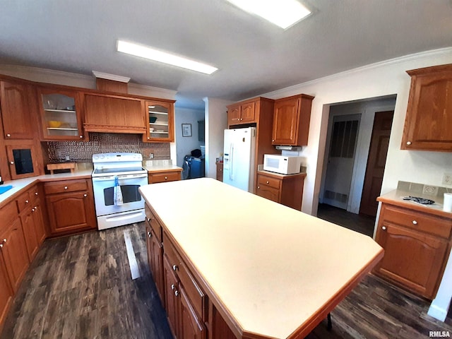 kitchen with crown molding, dark wood-type flooring, backsplash, and white appliances