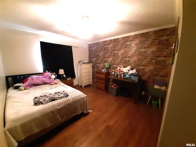 bedroom with ornamental molding, brick wall, and hardwood / wood-style floors