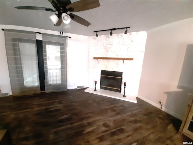 unfurnished living room featuring ceiling fan, dark hardwood / wood-style floors, and a fireplace