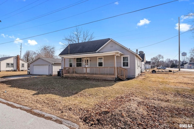 view of front of property with a porch, a garage, an outdoor structure, and a front lawn