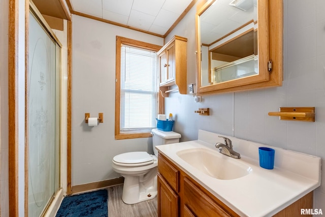 bathroom featuring hardwood / wood-style flooring, crown molding, vanity, an enclosed shower, and toilet