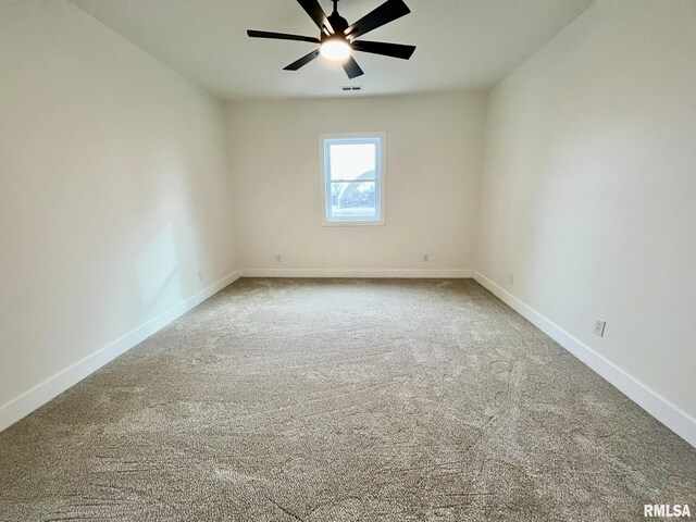 carpeted spare room with visible vents, baseboards, and ceiling fan