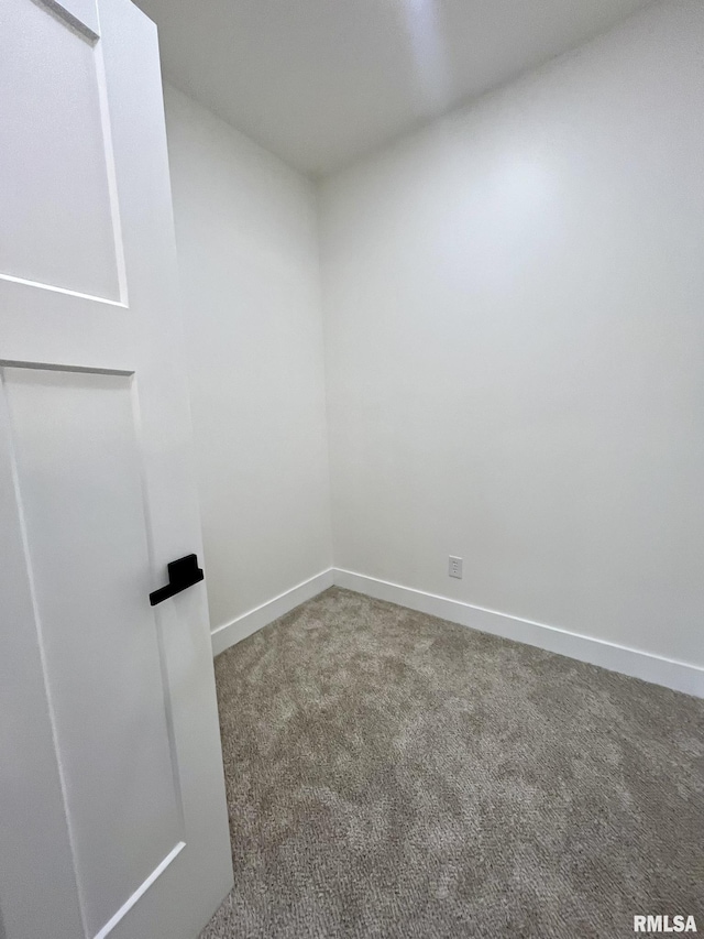 carpeted empty room featuring baseboards