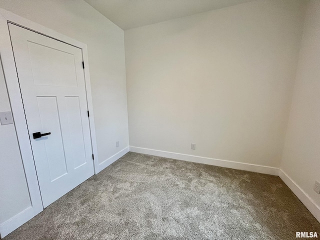 empty room featuring baseboards and carpet
