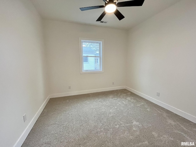 empty room featuring carpet flooring, a ceiling fan, visible vents, and baseboards