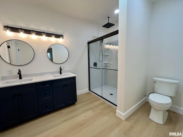 full bath with a sink, baseboards, wood finished floors, and a shower stall