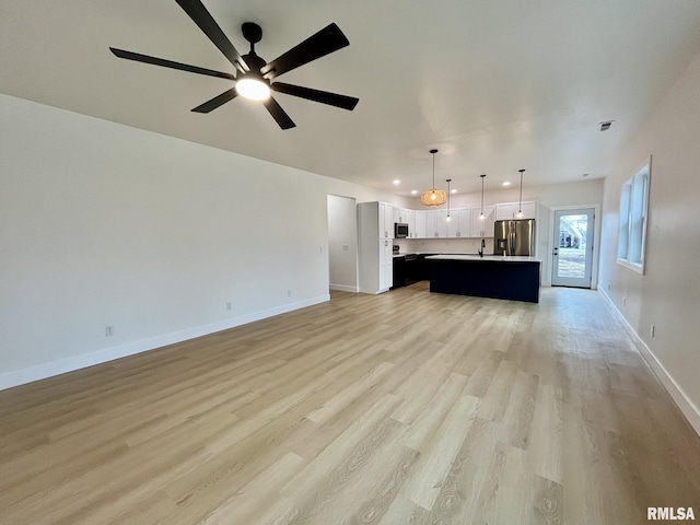 unfurnished living room featuring recessed lighting, ceiling fan, baseboards, and light wood-style floors