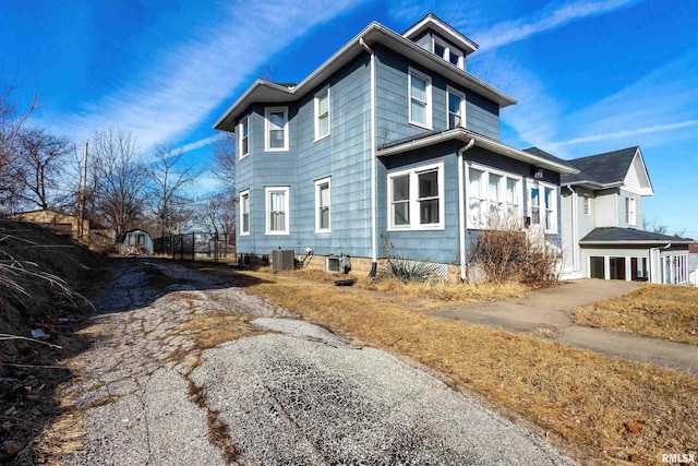 view of side of home with a garage and central AC unit