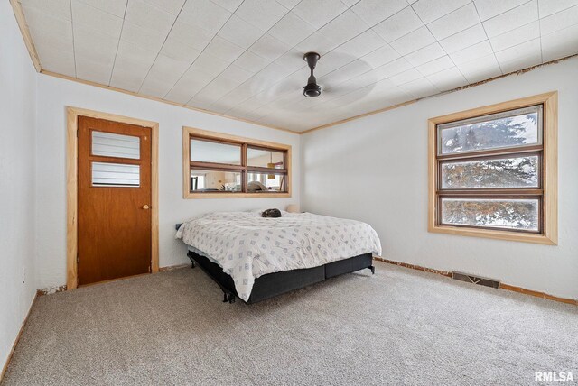 bedroom with a ceiling fan, carpet flooring, visible vents, and crown molding