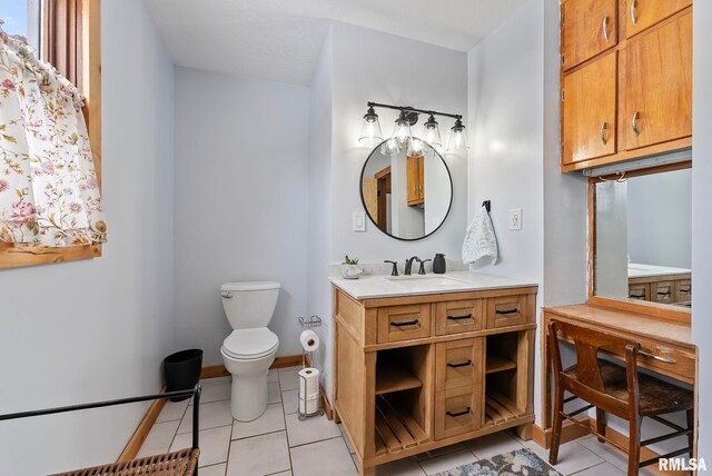 bathroom with baseboards, vanity, toilet, and tile patterned floors