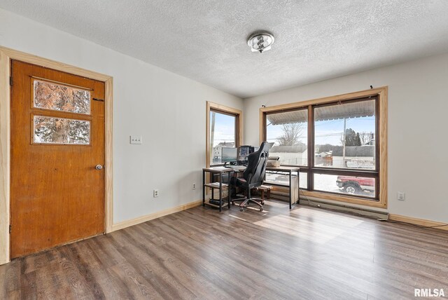 office with a textured ceiling, baseboards, and wood finished floors