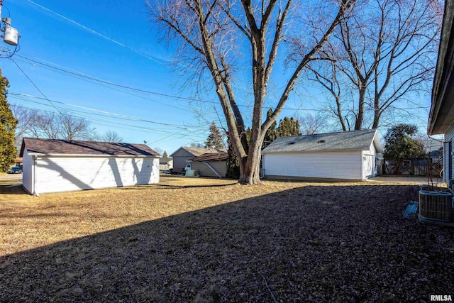 view of yard featuring cooling unit, a garage, and an outdoor structure