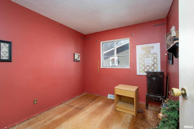 interior space featuring a textured ceiling and light hardwood / wood-style floors