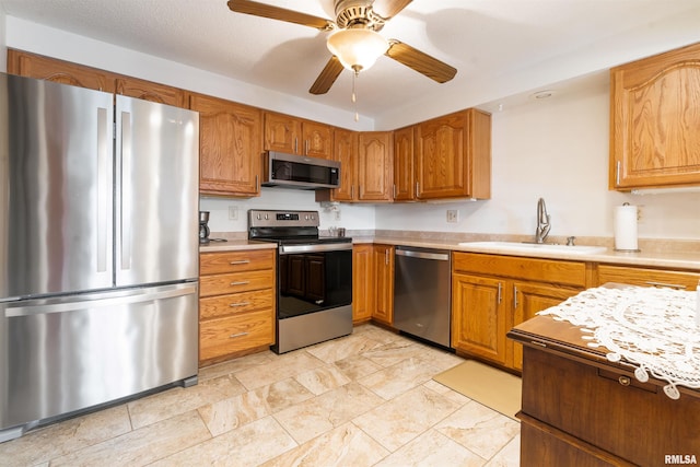 kitchen with appliances with stainless steel finishes, sink, and ceiling fan