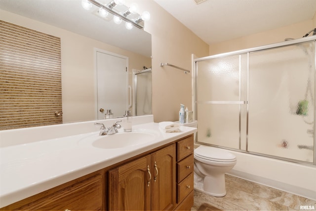 full bathroom featuring vanity, shower / bath combination with glass door, and toilet