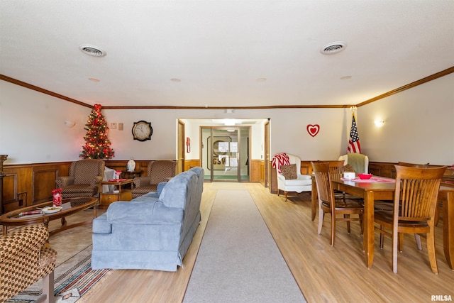 living room with ornamental molding and light hardwood / wood-style floors