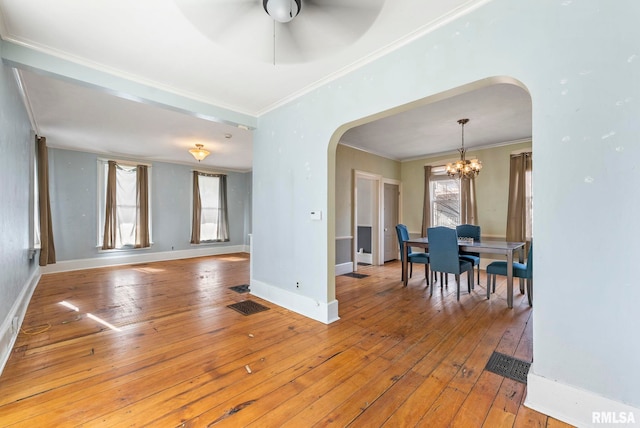 dining room with ceiling fan with notable chandelier, ornamental molding, and light hardwood / wood-style floors