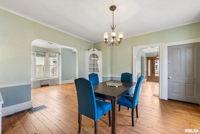 dining area featuring ornamental molding, a chandelier, and light hardwood / wood-style flooring