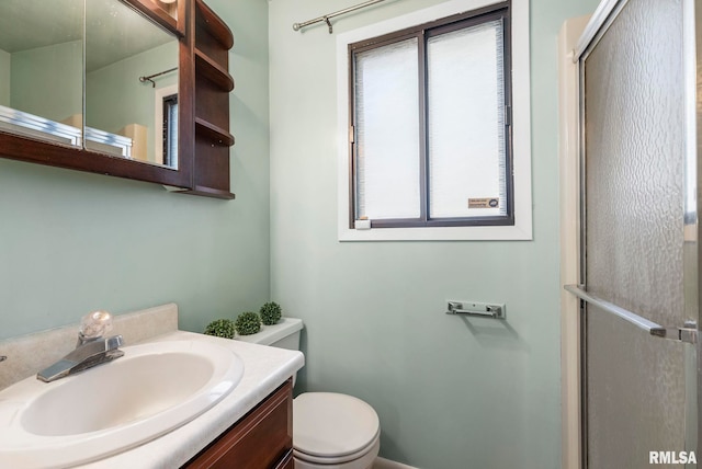 bathroom with walk in shower, vanity, and toilet