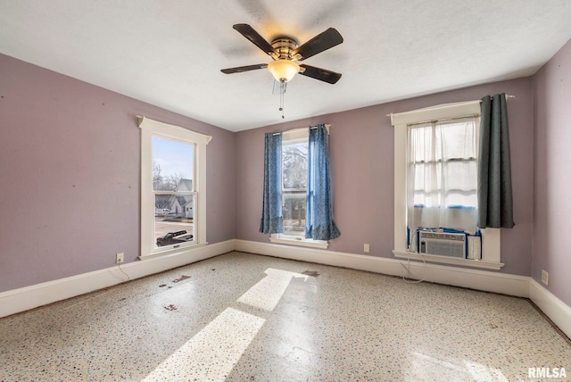 unfurnished room with a wealth of natural light, ceiling fan, and cooling unit