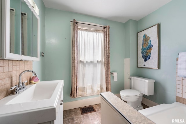 bathroom featuring tasteful backsplash, vanity, and toilet