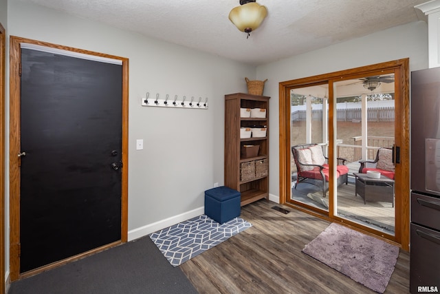 entryway with dark hardwood / wood-style flooring and a textured ceiling