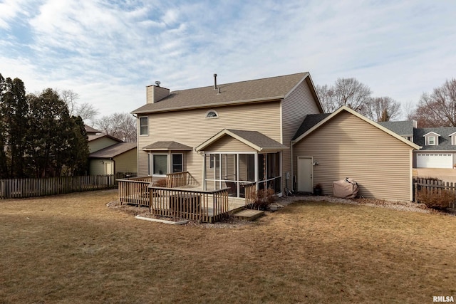 rear view of property with a wooden deck, a yard, and a sunroom