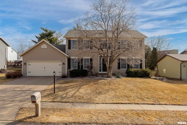 colonial house featuring a garage and a front lawn