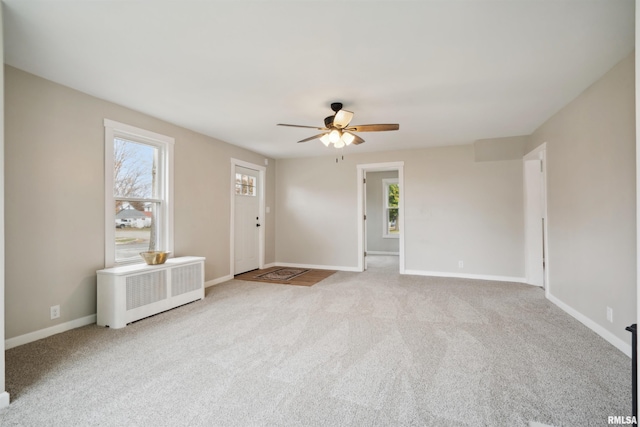 carpeted spare room with radiator heating unit and ceiling fan