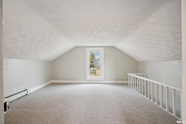 additional living space featuring carpet floors, a baseboard radiator, a textured ceiling, and vaulted ceiling