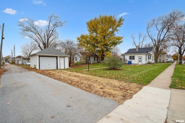 exterior space with a garage, an outbuilding, and a front lawn