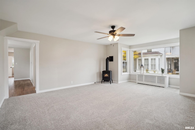 interior space featuring ceiling fan, radiator, and a wood stove