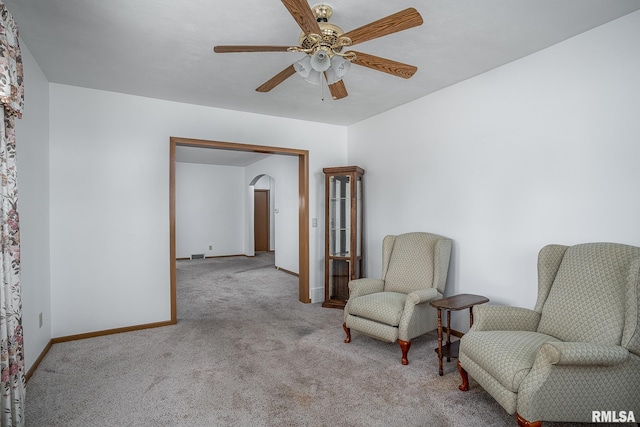 living area featuring light colored carpet and ceiling fan