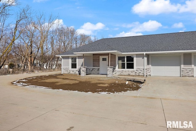 view of front of house with concrete driveway, roof with shingles, an attached garage, and stucco siding