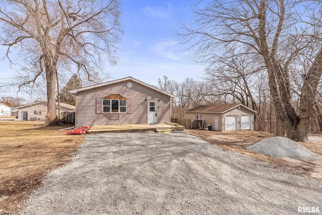 view of front facade with a garage, a deck, an outdoor structure, and driveway