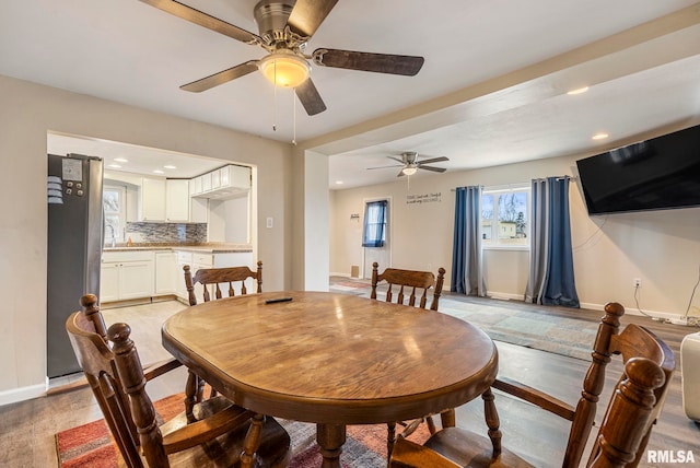 dining area with light wood-style flooring, baseboards, and recessed lighting